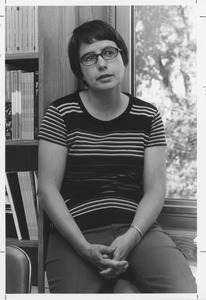 Ieda Wiarda seated next to a book shelf near a window in an office