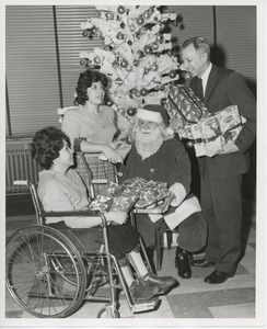 Santa Claus and Mr. Burrows giving gifts to international patients