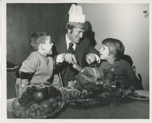 Actor Ken Hooper carving turkey for young clients