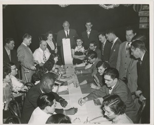 Group of people signing a scroll of paper