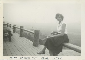 Bernice Kahn seated on fence on top of Cannon Mountain