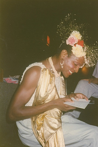 A Photograph of Marsha P. Johnson Reading a Letter at Her Birthday Party