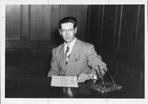 Suffolk University Athletics Director Charles Law (1946-1978), seated behind desk