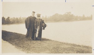 A graduate and his girl clowning on the banks of the reservoir