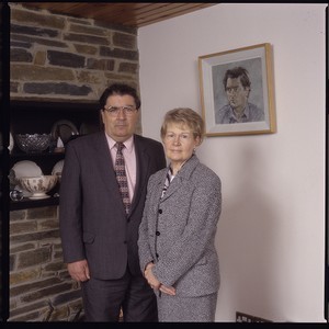 John Hume, leader of the SDLP, with wife Pat and portrait of himself, painted by Derek Hill, on the wall in the background