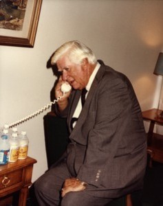 Thomas P. O'Neill speaking on the phone in the Speaker's office, sitting on arm of chair