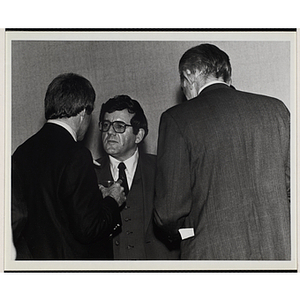 Three men stand together and converse at a Boys' Clubs of Boston event