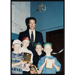 Former Boston Celtic Dave Cowens posing for a group picture with four boys wearing hats at a Kiwanis Awards Night