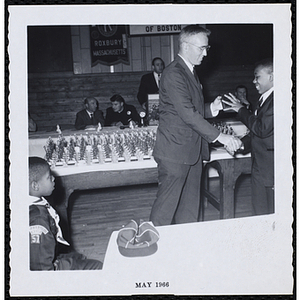 Thomas E. Leggat presents an award to a boy and shakes his hand at a Roxbury Kiwanis Club awards event