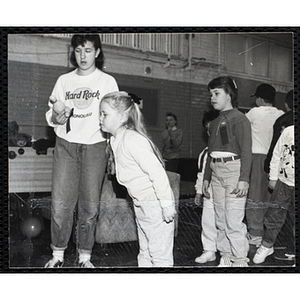 A girl leaning her body forward and looking to the front while two others stand beside her and look in the same direction at a joint Charlestown Boys & Girls Club and Charlestown Against Drugs (CHAD) event