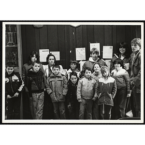 A dozen Boys & Girls Club members and two staffers posing against a wall