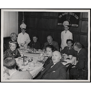 Two members of the Tom Pappas Chefs' Club serve a group of diners including Executive Director of Boys' Club of Boston Arthur T. Burger (center, back row)