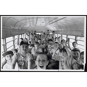 Boys pose for a group shot inside a school bus