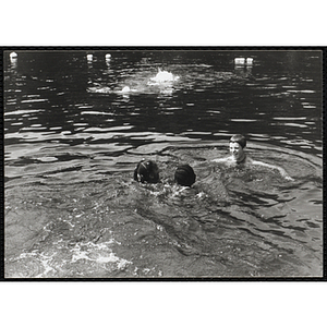 Two girls swimming with a supervisor