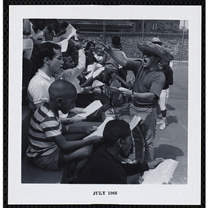 A man leads boys in a sing along on Tom Sawyer Day