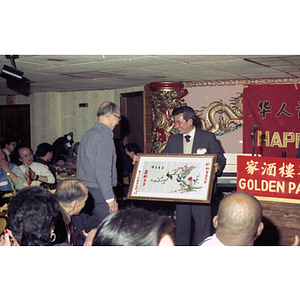 Henry Wong accepts a framed picture at a celebration of the Chinese New Year