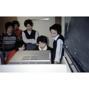 Chinese Progressive Association youth gather around a computer during a class