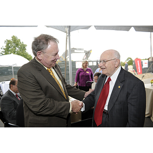 Dr. George J. Kostas shakes hands with Jack McCarthy, the Senior Vice President for Administration and Finance at Northeastern