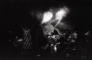 Taj Mahal in concert at Northfield, Mass.: Taj Mahal and horn section with light show behind