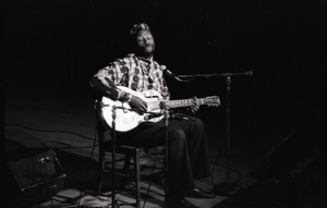 Taj Mahal in concert at Northfield, Mass.: Taj Mahal seated, playing steel guitar