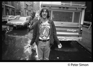 Crew member(?) in Grateful Dead shirt on rain soaked streets