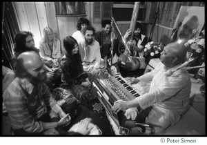 Amazing Grace members seated around an Indian harmonium player, Ram Dass seated directly in front