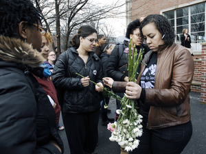Justice for Jason rally at UMass Amherst: Tracy Kelley, right, of the Committee for Justice for Jason Vassell, hands out flowers to students and staff marching in support of Vassell