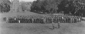Men gathered in formation on campus grounds