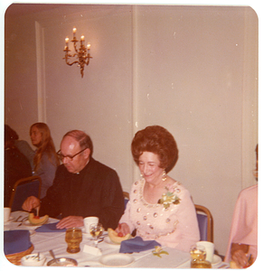 Deolinda Mello, sitting with priest