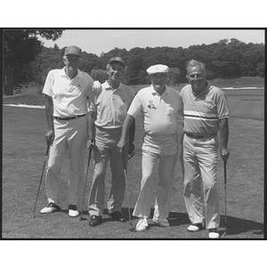 Four men posing on golf course
