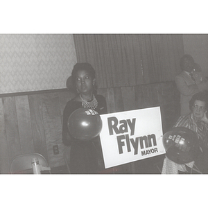 Carmen Pola stands with a "Ray Flynn Mayor" sign