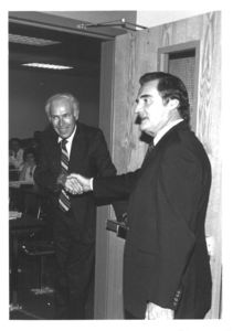 Suffolk University Professor Warren Briggs and Edward King shake hands outside of a classroom