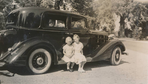 My sister Elsie and me sitting on the car in 1937