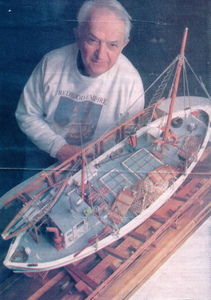 Adam Mello with ship he built