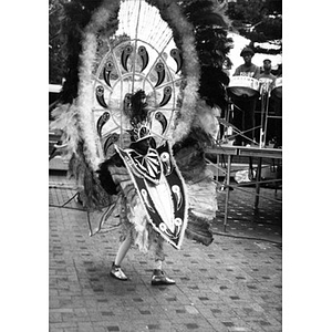 Dancer in elaborate feathered headdress and costume performing at Festival Betances.