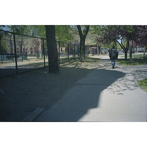 Chain link fence separating playground from sidewalk.