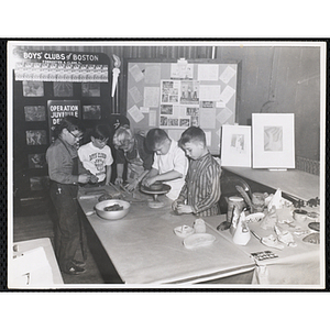 An art instructor and four boys work on clay projects in the "Boys' Clubs of Boston booth at Do-It-Yourself Show at Mechanics Building, Boston Nov. 25, 1957"