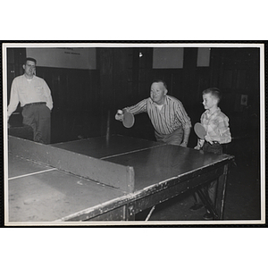 A man and a boy play table tennis