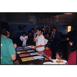 A Group of young women and girls standing at an activity sign-up table during an open house