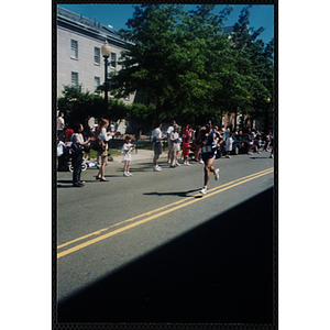 A man runs past cheering spectators during the Battle of Bunker Hill Road Race