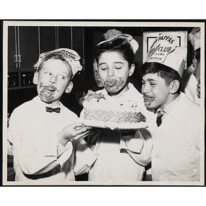 Members of the Tom Pappas Chefs' Club pose for a candid shot with a cake in a Brandeis University kitchen