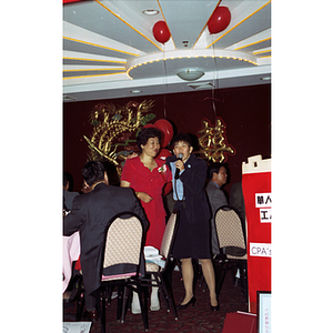 Woman has arm around award recipient during Chinese Progressive Association's 20th Anniversary Celebration