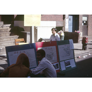 People viewing poster diagrams of housing redevelopment projects in Chinatown