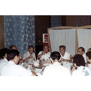 Chinese Progressive Association members sit around a dinner table at a restaurant in Guangzhou, China