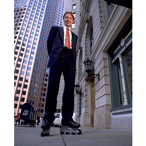 Business co-op student, Pavel Belogour, wearing business suit and roller blades in front of the Fidelity Investments building in downtown Boston, MA