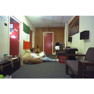 A student sits in the common area of his residence hall suite