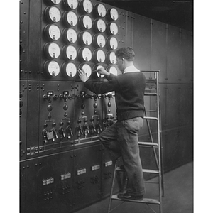 Student taking readings on a machine line at his electrical engineering co-op job