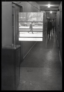 Double exposure: window superimposed on people walking in a hallway