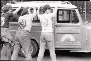 Three members of the Brotherhood of the Spirit Community feigning arrest, wearing Spirit in Flesh t-shirts and leaning against the Free Spirit Press van