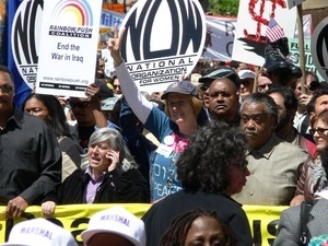 Cindy Sheehan and Al Sharpton at the head of the antiwar marchers in the streets of New York, with signs and banners opposing the war in Iraq